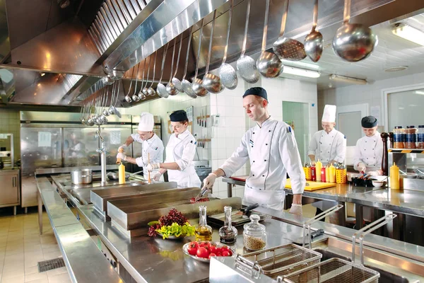 Moderne Küche. Köche bereiten die Mahlzeiten auf dem Herd in der Küche des Restaurants oder Hotels zu. Das Feuer in der Küche. — Stockfoto