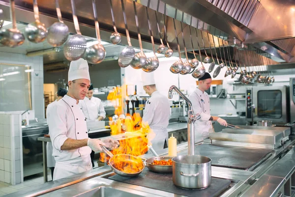 Cocina moderna. Los cocineros preparan comidas en la estufa en la cocina del restaurante u hotel. El fuego en la cocina. — Foto de Stock