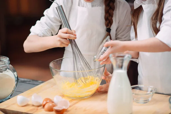 Meninas engraçadas crianças estão preparando a massa na cozinha . — Fotografia de Stock