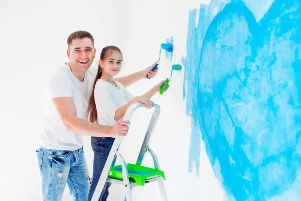 Father and his little daughter painting a wall in new home. — Stock Photo, Image