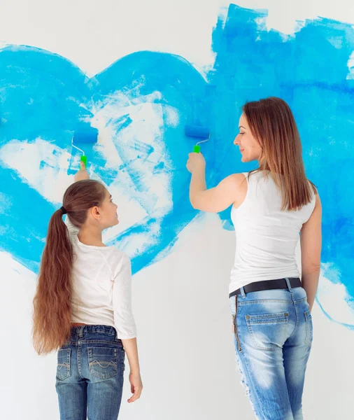 Madre, padre e hija pintando la pared en su nuevo hogar. — Foto de Stock