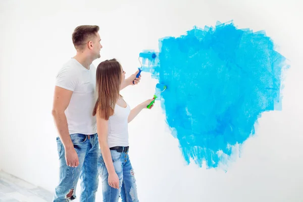 Happy couple painting walls in their new house ready for living together. — Stock Photo, Image