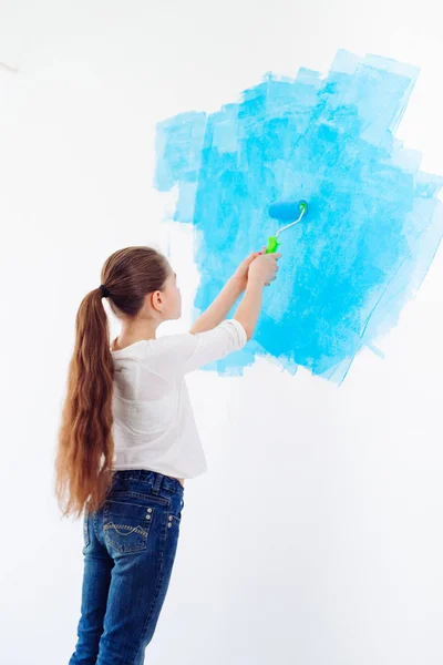 Reparatur in der Wohnung. Glückliches Kind malt die Wand mit blauer Farbe, — Stockfoto