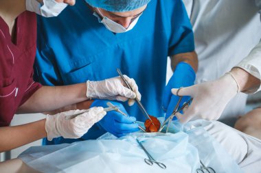 Cerrahi tiyatroda ameliyat eden bir grup cerrah iş başında. Koruyucu maske takan resüsitasyon tıp ekibi