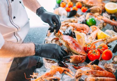 Şef, lokantadaki deniz ürünlerini bir tepsiye koyar..