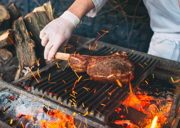 Σεφ μαγείρεμα μπριζόλα. Ο μάγειρας βάζει φωτιά στο κρέας.. — Φωτογραφία Αρχείου