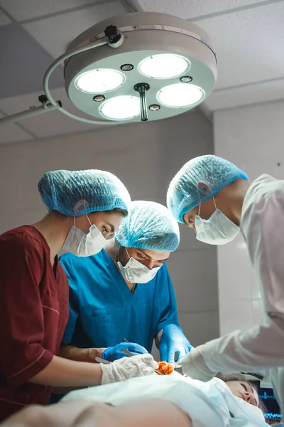 Skupina chirurgů pracujících v chirurgickém divadle. Resuscitační tým s ochrannými maskami — Stock fotografie