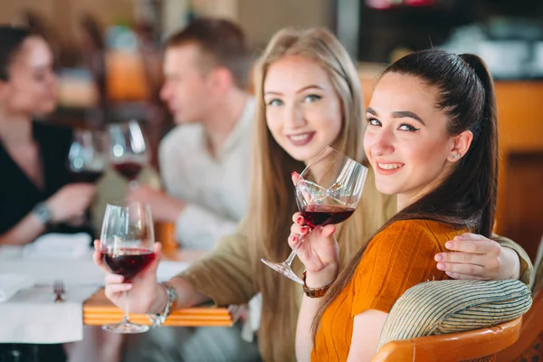Les amis s'amusent à boire du vin, à parler et à sourire au restaurant. — Photo