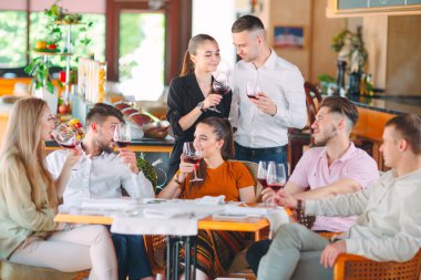 Arkadaşlar restoranın terasında şarap içerler..