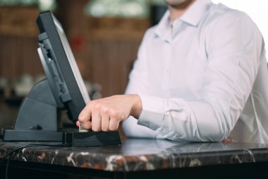 Küçük işletmeler, insanlar ve servis kavramı. Önlüklü mutlu bir adam ya da garson barda ya da kasada çalışıyor..