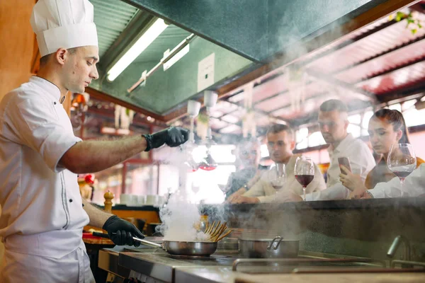 요리사는 식당에 있는 손님들 앞에서 음식을 준비 한다 — 스톡 사진