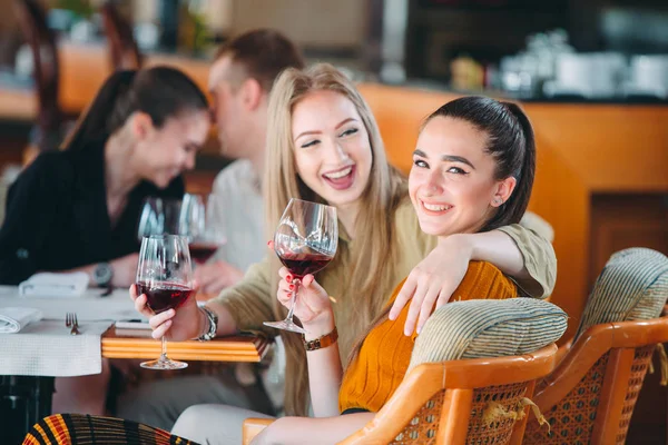 Les amis s'amusent à boire du vin, à parler et à sourire au restaurant. — Photo