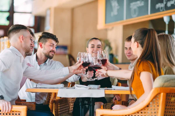 Les amis boivent du vin sur la terrasse du restaurant. — Photo