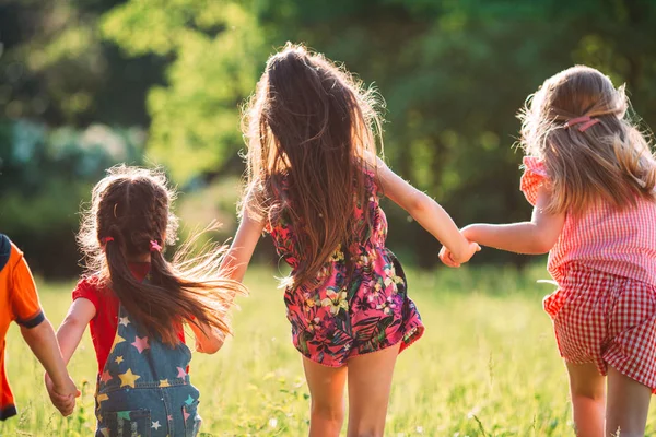 Gran grupo de niños, amigos, niños y niñas corriendo en el parque en el soleado día de verano con ropa casual . —  Fotos de Stock