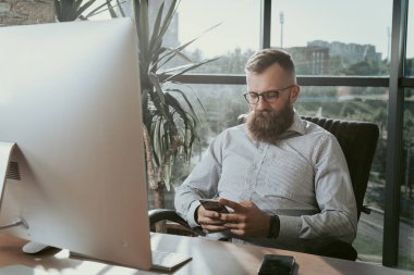 Telefon ofis masasında oturan işadamı.