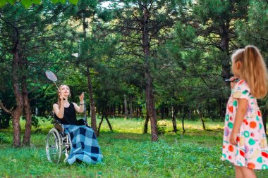 Genç engelli bir kız küçük kız kardeşiyle badminton oynar. Sağlıklı bir insanın engelli biriyle etkileşimi.