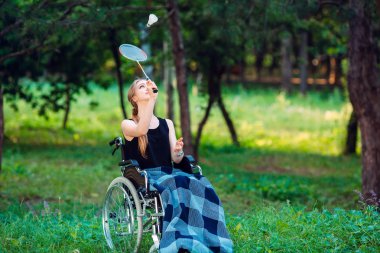 Genç engelli bir kız küçük kız kardeşiyle badminton oynar. Sağlıklı bir insanın engelli biriyle etkileşimi.