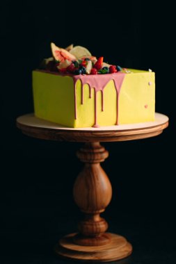 İncir, ahududu, yabanmersini ve limonla süslenmiş sarı turunçgil keki..