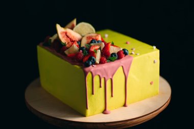 İncir, ahududu, yabanmersini ve limonla süslenmiş sarı turunçgil keki..