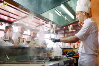 Şef restoranda ziyaretçilerin önünde yemek hazırlar.