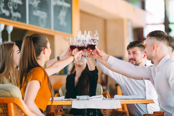 Amigos beben vino en la terraza del restaurante. —  Fotos de Stock