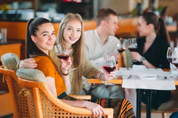 Gli amici si divertono a bere vino, parlare e sorridere al ristorante. — Foto Stock