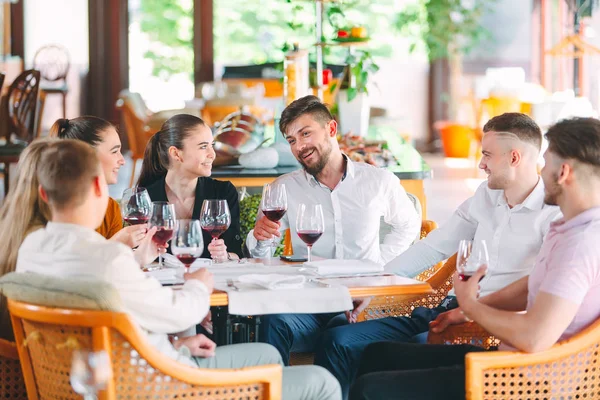 Amigos beben vino en la terraza del restaurante. —  Fotos de Stock