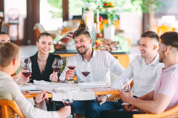 Amigos beben vino en la terraza del restaurante. —  Fotos de Stock