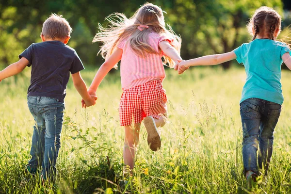 Gran grupo de niños, amigos, niños y niñas corriendo en el parque en el soleado día de verano con ropa casual . —  Fotos de Stock