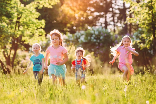 Gran grupo de niños, amigos, niños y niñas corriendo en el parque en el soleado día de verano con ropa casual . —  Fotos de Stock