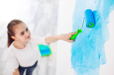 Apartmanda tamirat var. Mutlu çocuk duvarı mavi boyayla boyuyor.,