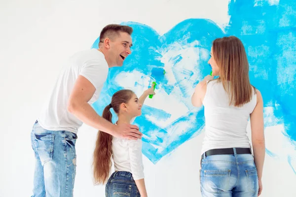 Mother, father and little daughter painting the wall in their new home. — Stock Photo, Image