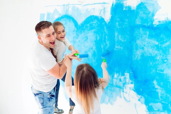 Mother, father and little daughter painting the wall in their new home. — Stock Photo, Image