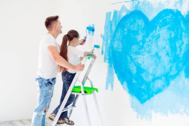 Babası ve küçük kızı yeni evlerinde duvar boyuyor..