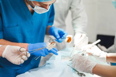 Cerrahi tiyatroda çalışan bir grup cerrah. Kurtarma ekibi koruyucu maskeler takıyor çelik tıbbi aletler tutuyor hastayı kurtarıyor. Ameliyat ve acil durum konsepti.