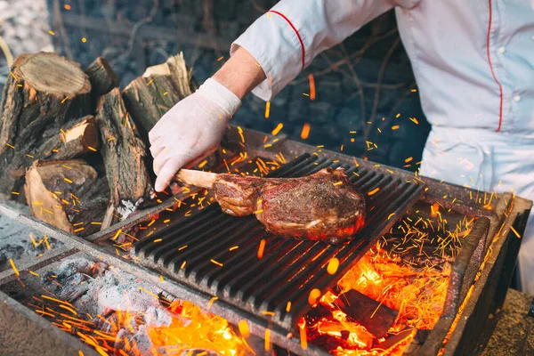Chef Cooking steak. Cozinheiro vira a carne no fogo. — Fotografia de Stock