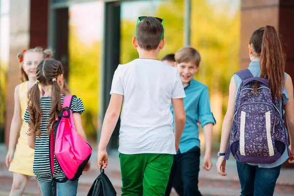 Schoolvrienden gaan naar school. Studenten begroeten elkaar. — Stockfoto