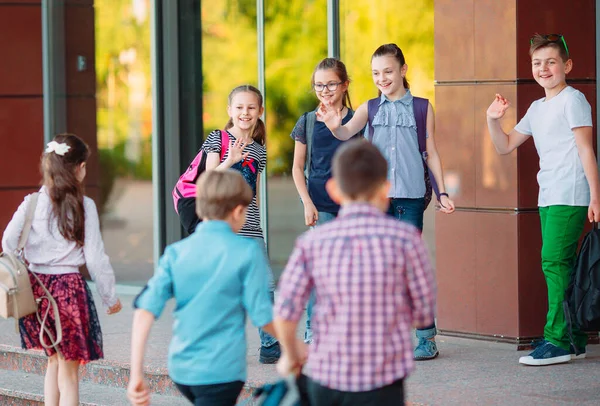 Schoolvrienden gaan naar school. Studenten begroeten elkaar. — Stockfoto