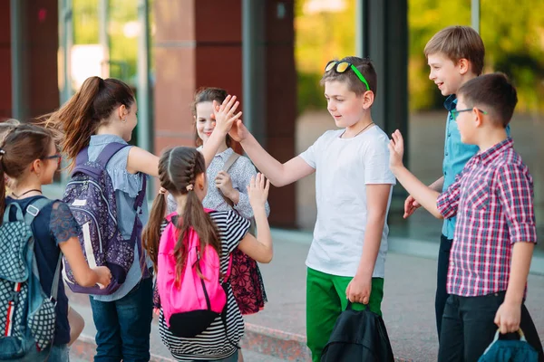 Schoolvrienden gaan naar school. Studenten begroeten elkaar. — Stockfoto