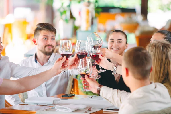 Amigos beben vino en la terraza del restaurante. —  Fotos de Stock