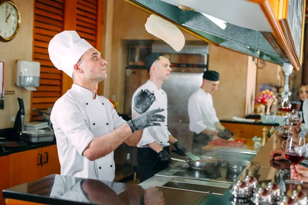 Lo chef prepara il cibo davanti ai visitatori del ristorante — Foto Stock