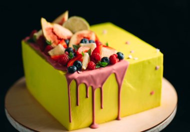 İncir, ahududu, yabanmersini ve limonla süslenmiş sarı turunçgil keki..