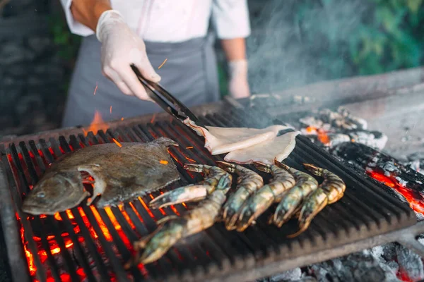 Mariscos en la parrilla. Mejillones, camarones, calamares y pescado se cocinan al fuego. —  Fotos de Stock