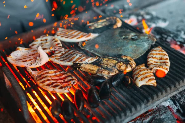 Mariscos en la parrilla. Mejillones, camarones, calamares y pescado se cocinan al fuego. —  Fotos de Stock