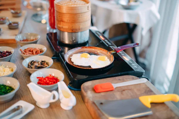 Ontbijt. Roerei wordt gekookt op een inductie fornuis in het restaurant. — Stockfoto
