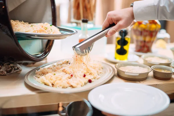 Капуста. Завтрак в отеле или ресторане. Официант кладет квашеную капусту в тарелку. — стоковое фото