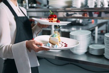 Garson lokantada görev başında. Garson bulaşıkları taşıyor..