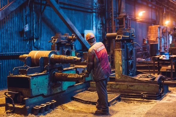 Trabalhador da indústria pesada trabalhando duro na máquina. Ambiente industrial áspero — Fotografia de Stock
