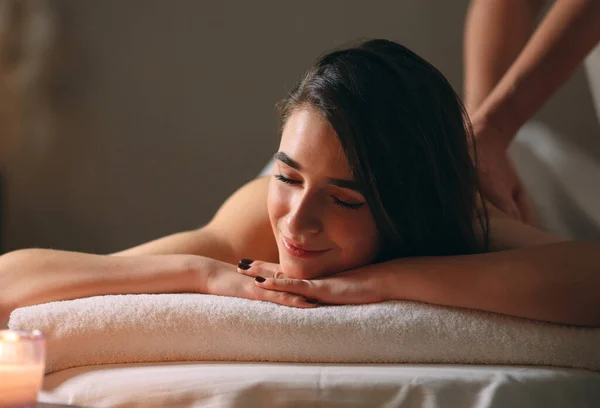 Spa, massage. Ung mörkhårig vacker flicka som gör massage. — Stockfoto