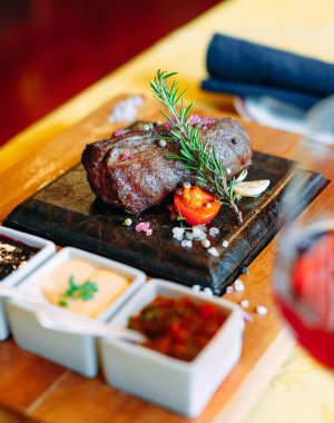 Restoran yemeği. Taze sebzeli ızgara domuz eti. Bitki ve baharatlı madalyonlar..